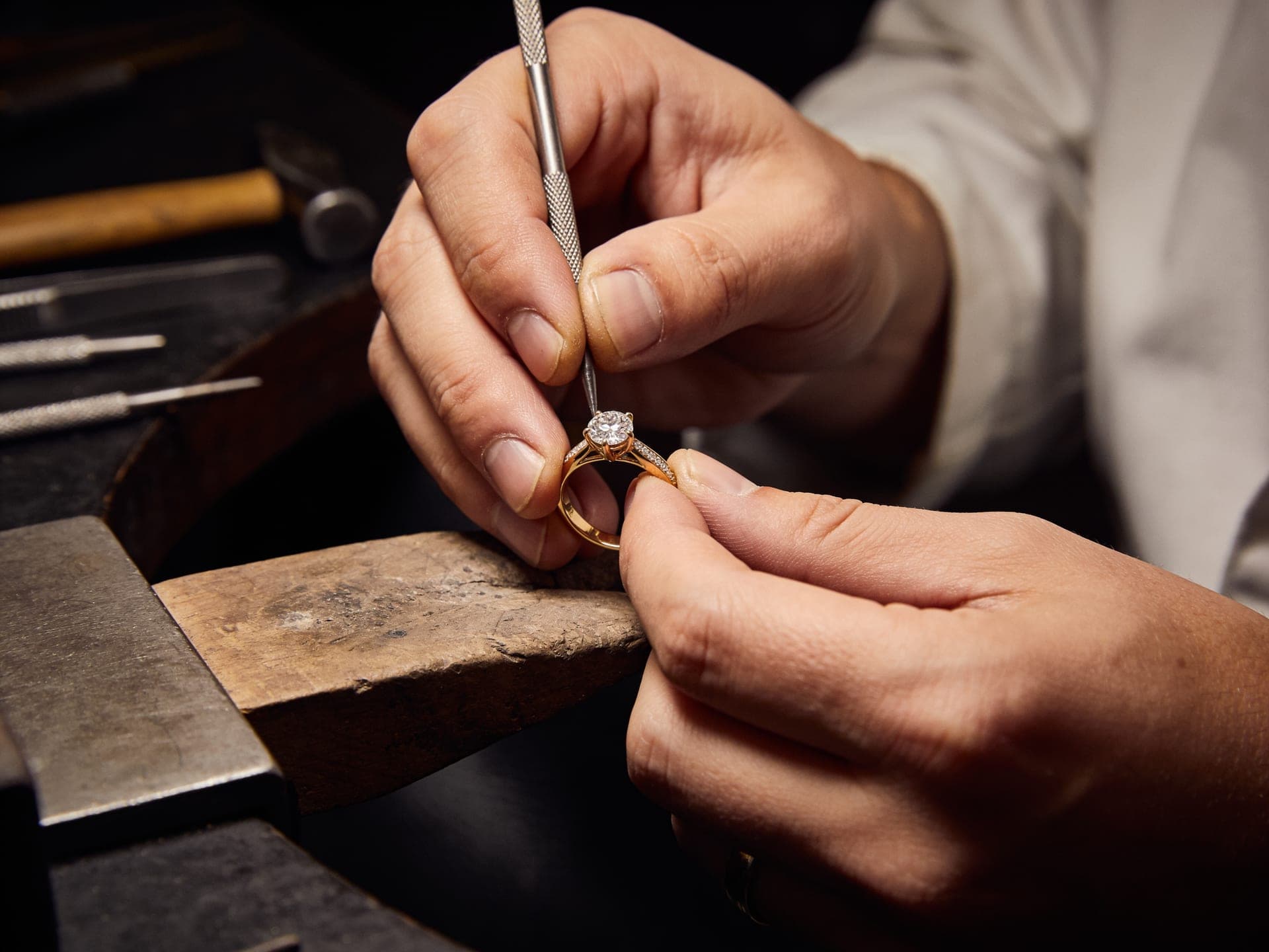 An Orène jeweler setting a diamond into a gold ring at the bench